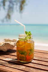 wooden table at a beach bar with a drink in front of turquoise water Ko Samui, thailand