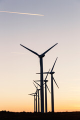 Wind Turbines at Dusk. Landscape sunset with windmills. Renewal source of electricity. Wind turbines field new technology for clean energy on mountain, sunset view with colorful twilight on sky.