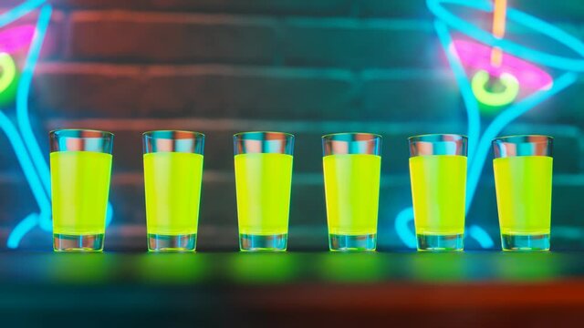 Green shots on the bar. Colourful alcoholic drinks on the table in a nightclub.
