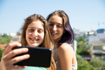 Two Teenage Girls Taking Selfie With A Mobile Phone