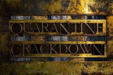 Quarantine Crackdown text formed with real authentic typeset letters on vintage textured silver grunge copper and gold background