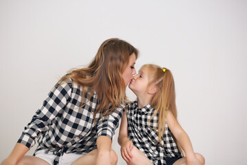 Happy loving family. Mother and her girl play, kiss and hug.