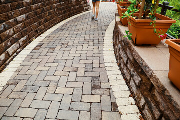 Weathered stone brick pathway on an outdoor patio walkway path with a person walking or running