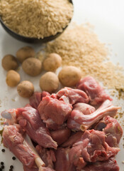 Close-up of mutton with raw potatoes and rice