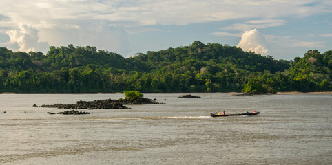indigeneous boat on a river in the amazon rainforest