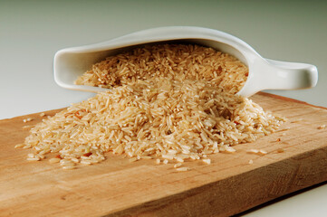 Close-up of brown rice spilling from a ceramic jug