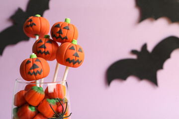 Delicious Halloween themed cake pops on pink background, closeup. Space for text