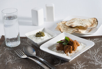 Close-up of mutton curry served with rice and papadums