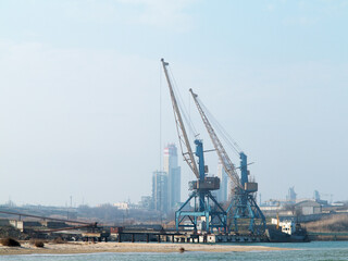 Fototapeta na wymiar Harbor crane. Two old rusty cranes in an industrial port in the fog.