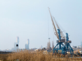 Fototapeta premium Harbor crane. Two old rusty cranes in an industrial port in the fog.