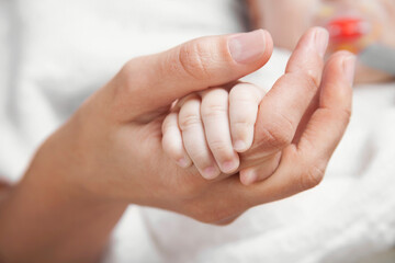 Woman holding her baby's hand