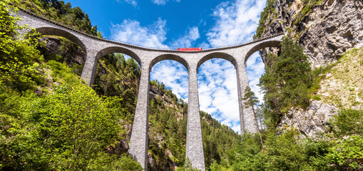 Landschap met Landwasser-Viaduct in de zomer, Filisur, Zwitserland. Panoramisch zicht op hoge spoorbrug en rode trein.