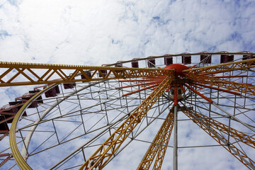 Ferris wheel against a blue sky on a sunny day. Recreation and entertainment. Amusement rides in the city park Odessa, Ukraine