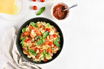 Tomato and bacon pasta with parmesan cheese and basil leaves