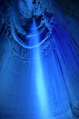 Tall waterfall in a dark cavern with blue lighting