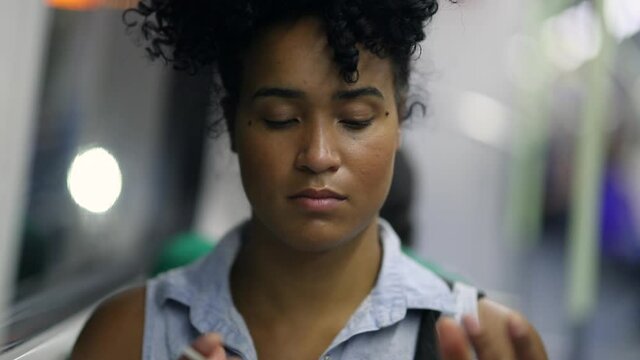 Mixed race young woman portrait face in subway metro, pensive black woman