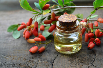 Barberry essential oil in a glass bottle on old wooden table for aromatherapy,skin care or...