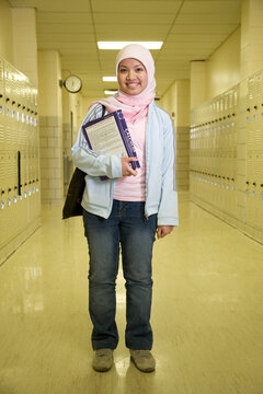 Indonesian teenager wearing headscarf in school hallway