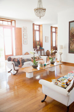 Hispanic couple napping on sofa in living room