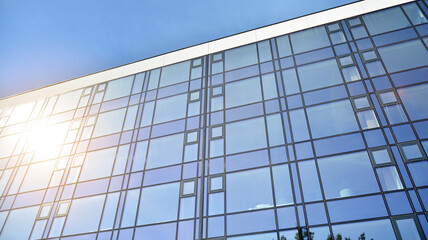 Fototapeta na wymiar Office building, details of blue glass wall and sun reflections.