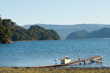 Fototapeta na wymiar Pier with canoe at lake, Alumine Lake, Cordillera de los Andes, Neuquen Province, Argentina