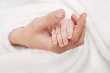 Woman holding her baby's hand