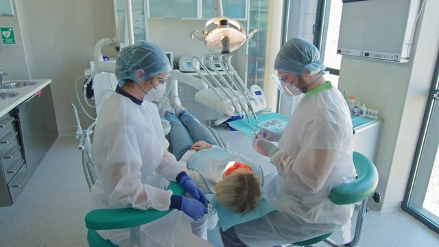 Dentist and nurse treating patient in dentists office