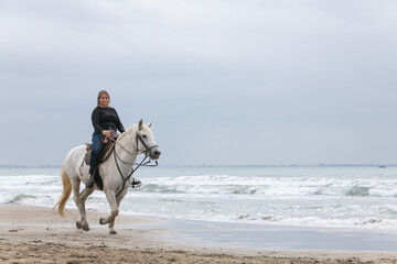 young woman on a horse on the beach