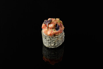 Maki - squid, avocado, snow crab, blue cheese sauce, masago, wasabi on black background