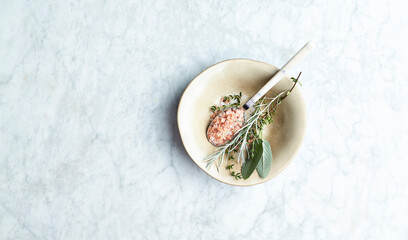 Fresh organic Herbs and Himalayan Salt on marble background. Flat lay. Copy space