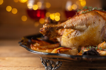 Thanksgiving turkey with a baked potatoes isolated on wooden background with bright yellow lamps and two wineglasses with red wine. The traditional Thanksgiving dinner. Holiday concept. Top view.