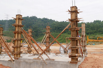 KUALA LUMPUR, MALAYSIA -SEPTEMBER 19, 2020: Column timber form work and reinforcement bar at the construction site. Installed by construction workers. The structure supported by temporary wood support