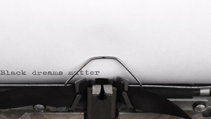 typing a quote black dreams matter on a vintage typewriter close-up