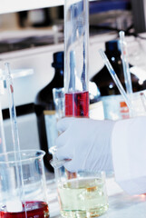 Close-up of a person's hand holding a graduated cylinder