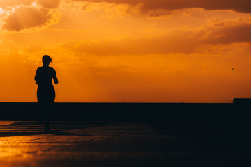 Fototapeta premium Atardecer mujer corriendo haciendo deporte