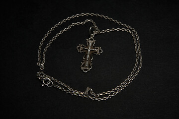 Cross with chain on a dark background.