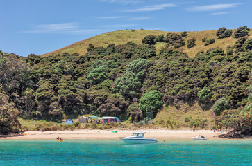 Fototapeta na wymiar Beach life with turquoise water and boats in Bay of Islands, New Zealand