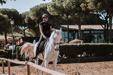 Caballo español en una hipica en andalucia con su Jinete Amazona montandolo con sus riendas y...
