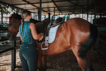 Caballo español en una hipica en andalucia con su Jinete Amazona montandolo con sus riendas y...