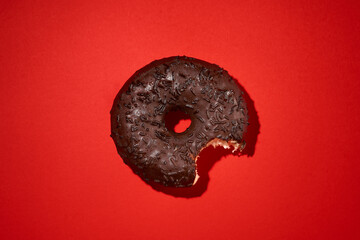 bitten donut on a red background, a donut in the icing