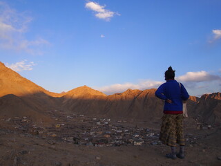 Fototapeta premium A woman looking down on the historic city streets, Leh, Ladakh, Jammu and Kashmir, India