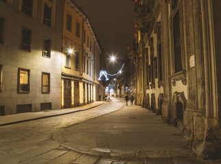 Deserted street with Xmas lights. Christmas city decorations. Festive illumination in Milan center.Italy