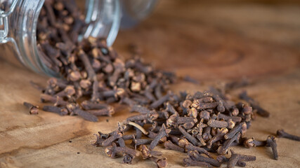 Clove spice sprinkled from a glass jar