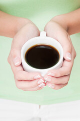 Mid section view of a woman holding a cup of black coffee