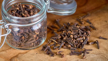 Clove spice sprinkled from a glass jar