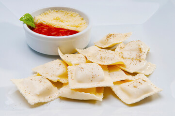 High angle view of ravioli served with tomato sauce and grated cheese