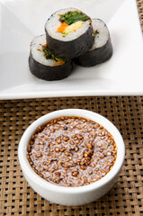 Close-up of sushi rolls with sesame seed dip