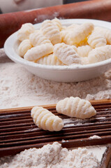 Fototapeta na wymiar Bowl of homemade gnocchi with mould and a rolling pin
