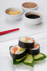 Close-up of sushi rolls on zucchini with condiments