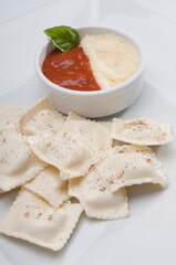 High angle view of ravioli served with tomato sauce and grated cheese